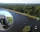 Widok na zbiornik wodny z zaporą i spływającą wodą. Na wodzie kilka łodzi, w tle las i zabudowania. To piękne **chechło** jest idealnym miejscem do wypoczynku.