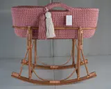Moisés crochet rosa con borlas y base de mimbre. Un lugar acogedor para el bebé.