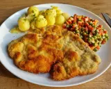 Dwa złociste schabowe w mleku, podane z ziemniaczkami i warzywami. Pyszny obiad gotowy!