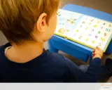 Bambino con libro di numeri colorati, parte di un test logopedia bambini.