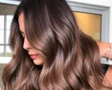 Capelli castani morbidi e luminosi, perfetti per un look estivo. Le onde leggere incorniciano il viso, creando un effetto naturale e chic.