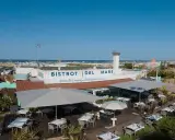 Il Bistrot del Mare a Rimini, con tavoli all'aperto e vista sulla spiaggia affollata, offre specialità romagnole.