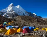 Obóz pod majestatycznym szczytem Karakorum. Kolorowe namioty rozstawione na kamienistym zboczu, gotowe na przyjęcie alpinistów.