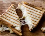 Pyszny, ciągnący się ser w tostach. Zastanawiasz się, ile kcal ma tost z serem? Ten wygląda na około 300-400 kcal.