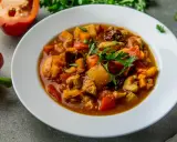 Gęsty gulasz z indyka z papryką i ziemniakami, udekorowany natką pietruszki. Aromatyczne danie, które rozgrzewa.