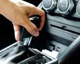 Mano operando la palanca de **cambio automático como funciona** en un coche moderno.