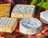 Assortiment de fromages, dont un en forme de cœur, évoquant les spécialités culinaires de Rouen.