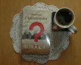 Kawa i książka Joanny Chmielewskiej "Gwałt" na koronkowym obrusie. Idealny zestaw do czytania jej kryminałów chronologicznie.