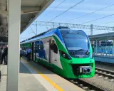 Nowy pociąg na trasie Rzeszów czeka na pasażerów. Zielono-niebieski skład stoi na peronie.