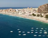 Traumhafte Küstenlandschaft an der Costa Tropical mit weißem Sandstrand, türkisfarbenem Meer und vielen kleinen Booten.