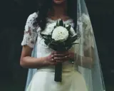 Panna młoda z bukietem białych róż, w welonie i koronkowej sukni. W myślach słyszy "Ave Maria po polsku na ślub tekst".