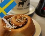 Słodka bułeczka cynamonowa z posypką i flagą Szwecji. To właśnie z takich wypieków słynie Szwecja, idealna na fika.
