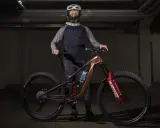 Kolarz w kasku i odzieży rowerowej prezentuje nowoczesny rower MTB. To sprzęt do ekstremalnej jazdy, a rowery mtb co to znaczy? To rowery górskie do trudnych tras.