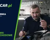 Mężczyzna trzymający żarówkę samochodową w warsztacie.