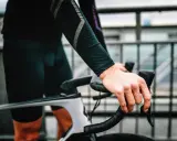 Rowerzysta z silnym bólem ud po jeździe na rowerze, trzymający kierownicę.