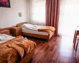 Pokój w sanatorium Busko-Zdrój, prywatnie Krystyna. Dwa łóżka, szafki nocne, stół z krzesłem i butelkami wody.
