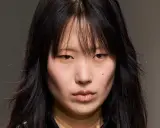Rostro de modelo con cabello negro y flequillo desordenado, un corte **hush cut** que enmarca su rostro.