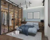 Chambre moderne avec dressing vitré bien organisé, lit bleu douillet et deux cadres vides au mur.