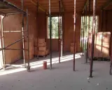 Budowa w toku: szalowanie stropu, rusztowania i materiały budowlane czekają na beton.