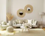 Un salon boheme nature avec un fauteuil douillet, un canapé confortable, des coussins texturés, des miroirs en rotin et des herbes séchées.