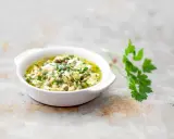 Sauce gribiche, une préparation maison à base d'œufs durs hachés, de câpres et de persil frais, dans un bol blanc.