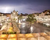 Nocny rzeszów rynek podczas burzy z piorunami. Mokry bruk, oświetlone kamienice i ogródki restauracyjne pod namiotami tworzą magiczny klimat.