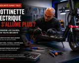Un technicien vérifie le fusible d'une trottinette électrique Urban Glide qui ne s'allume plus. Outils et multimètre à proximité.
