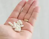 Garść białych kapsułek na dłoni. Czy cytrynian magnezu jest szkodliwy? Suplementy magnezu są zazwyczaj bezpieczne.