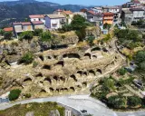 Antiche abitazioni rupestri scavate nella roccia sul Monte Poro, Calabria. Un villaggio arroccato tra le colline verdi.