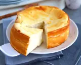 Un délicieux gâteau au fromage blanc, doré et moelleux, avec une part déjà servie sur une pelle à tarte.