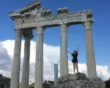 Radosna turystka pozuje na tle antycznych ruin w Side, Turcja.