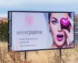 Reklama salonu "Sekret Piękna" z wizerunkiem kobiety i sercem. Personalizacja reklam pozwala dotrzeć do klientów z ofertą dopasowaną do ich potrzeb.