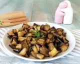 Melanzane in friggitrice ad aria, dorate e saporite, pronte per essere gustate. Un rametto di rosmarino le impreziosisce.