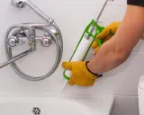 Person dichtet mit Silikon ab, um Gerüche zu entfernen.