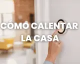 A mano ajusta un termostato inteligente, mostrando cómo calentar una casa económicamente.