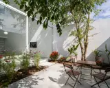 Un patio moderno con mesa y sillas de madera, flores y un árbol. ¡Excelentes ideas para porches pequeños y acogedores!
