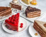 Variedad de pasteles en una mesa: uno de chocolate con cacao, otro con glaseado rojo y frambuesas, y uno con nueces. Una deliciosa carta de postres.