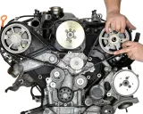 Wymiana rozrządu OM651 cena. Mechanik sprawdza stan paska rozrządu w silniku.