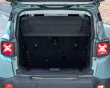 Maletero abierto de un Jeep Renegade color verde menta, mostrando el espacio de carga y la tapa retráctil.