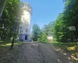 Wieża widokowa na grzybek jelenia góra, otoczona zielenią, z tablicami informacyjnymi i latarniami.