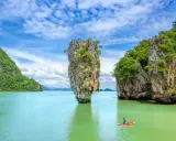 Wyspa Phuket, Tajlandia: samotna skała wyrasta z turkusowej wody, a kajakarz podziwia krajobraz.