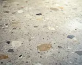 Superficie de terrazo con fragmentos de piedra de diversos colores, lista para pulir y revelar su brillo natural.