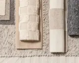 Olika mattprover i neutrala färger. En matta med textur och fransar, en med blockränder och en med rutmönster. Perfekt för att välja blw mat.