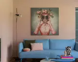 Ein hellblaues Sofa mit Kissen vor einem Bild, das eine Frau mit Blumenkranz und Schmetterlingen zeigt. Ein Beispiel für die Wohntrends 2026.