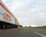 Camión de carga con el logo "Supply Chain Solutions" y "Turners" avanza por la autopista.