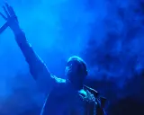 Kanye West z mikrofonem w dłoni, w niebieskiej poświacie. W tle dym, przypominający atmosferę z jego albumów.