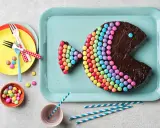 Un délicieux gâteau chocolat en forme de poisson, décoré de bonbons colorés. Parfait pour une fête !