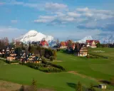 Malownicze domy w Murzasichlu z widokiem na ośnieżone Tatry. Atrakcje tego miejsca to przede wszystkim piękno przyrody i spokój.