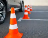 Pomarańczowe pachołki na placu manewrowym. Zastanawiasz się, jakie prawo jazdy potrzebne na autolawetę?
