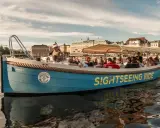 En blå båt med texten "SIGHTSEEING RIDE" tar passagerare på en tur i Stockholm.